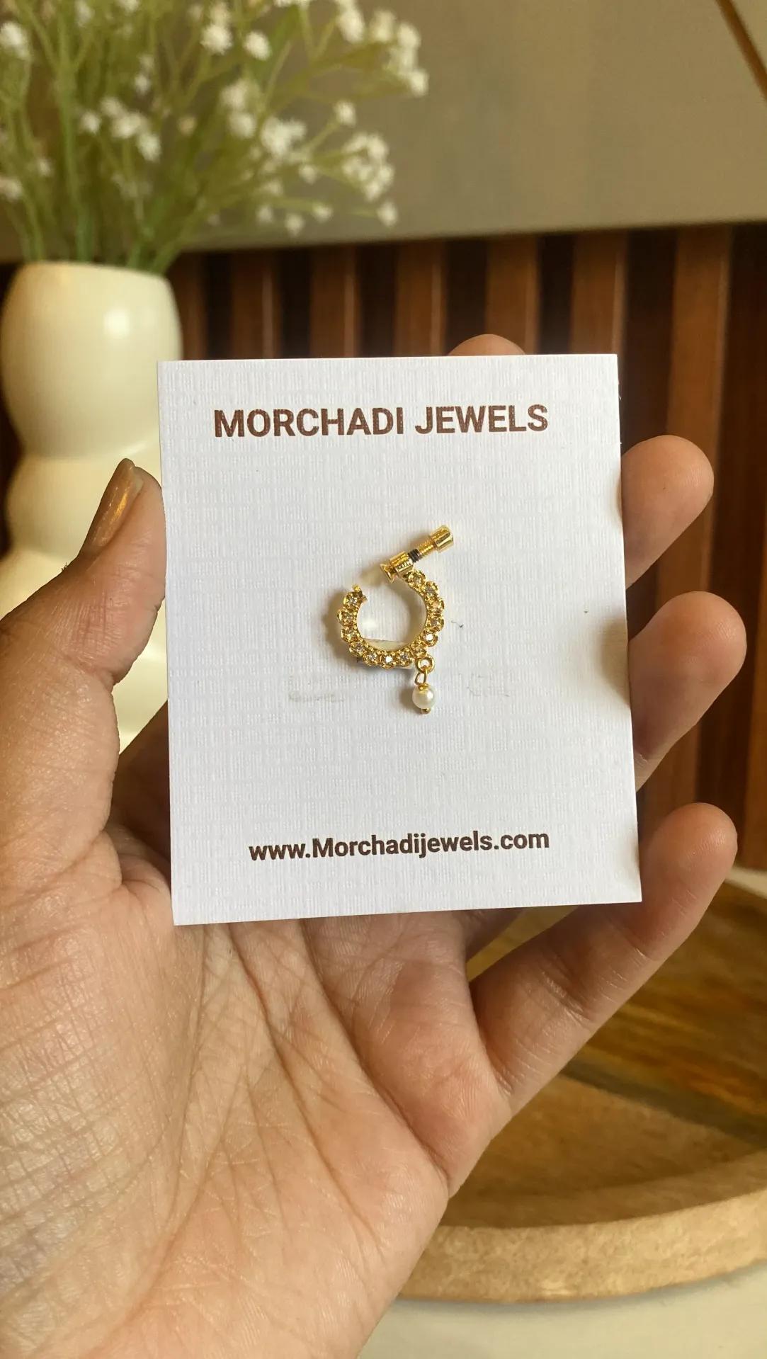 Gold-toned nath set with clear stones around the ring, screw-fit post and a small pearl-look drop