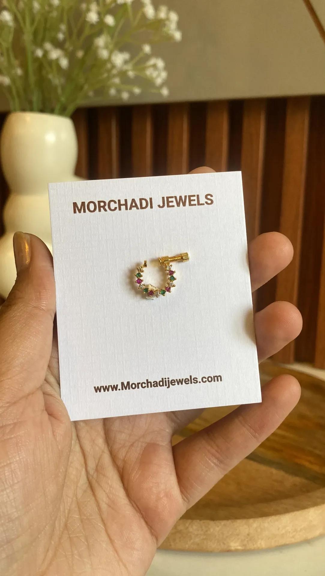 Gold-toned nath ring set edge to edge with pink, green and clear stones, no drop charm
