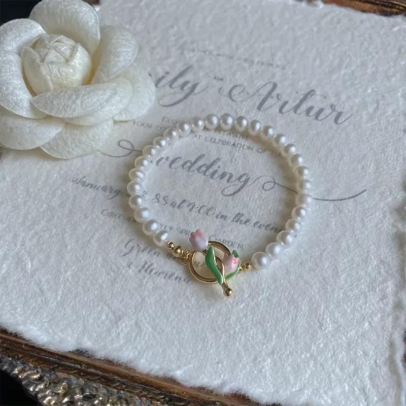 Faux baroque pearl bead bracelet with a gold tulip-shaped toggle clasp in pink and green enamel