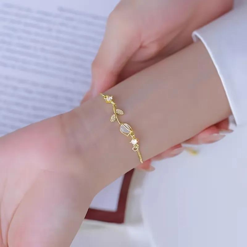 Gold-plated vine bracelet with a cat's-eye glass bead and small pave leaf details, pull-chain closure